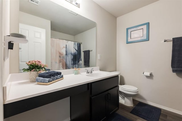 full bath featuring baseboards, visible vents, toilet, wood finished floors, and vanity