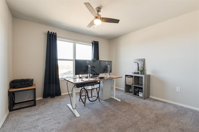 carpeted office with ceiling fan and baseboards