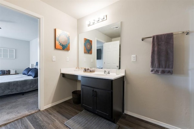 bathroom featuring visible vents, vanity, baseboards, and wood finished floors