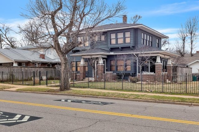 2215 N Shartel Ave, Oklahoma City, OK 73103 - view of front facade featuring brick siding, a chimney, and a fenced front yard
