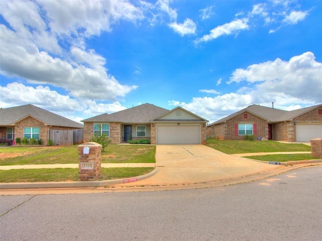 single story home featuring a garage, concrete driveway, a front lawn, and brick siding