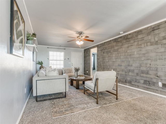 carpeted living room featuring crown molding, baseboards, and ceiling fan