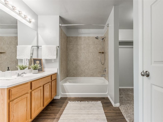 bathroom with baseboards, vanity, shower / bathtub combination, and wood finished floors