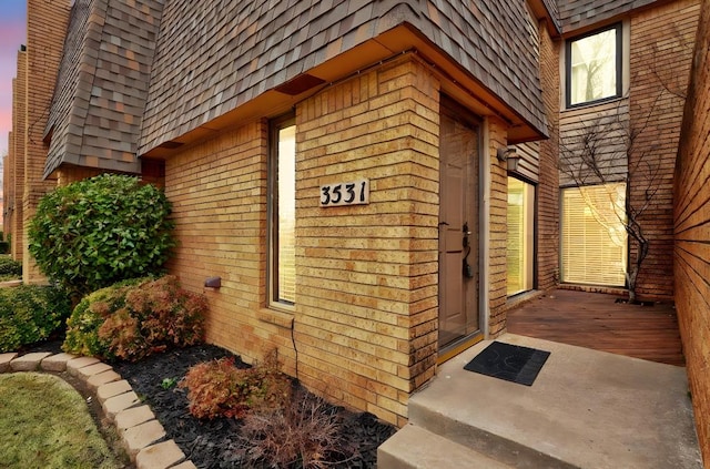 property entrance with mansard roof and roof with shingles