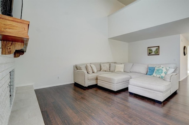 living room with a fireplace, wood finished floors, and baseboards