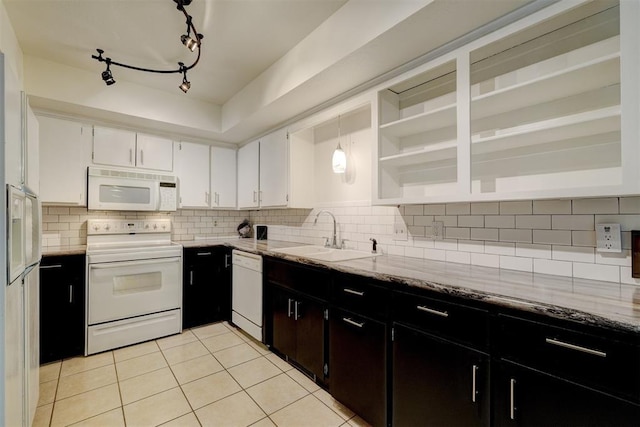 kitchen featuring white appliances, white cabinets, a sink, and backsplash