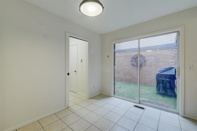 unfurnished room with light tile patterned floors, visible vents, and baseboards