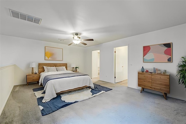 bedroom with visible vents, ceiling fan, light carpet, and ensuite bathroom