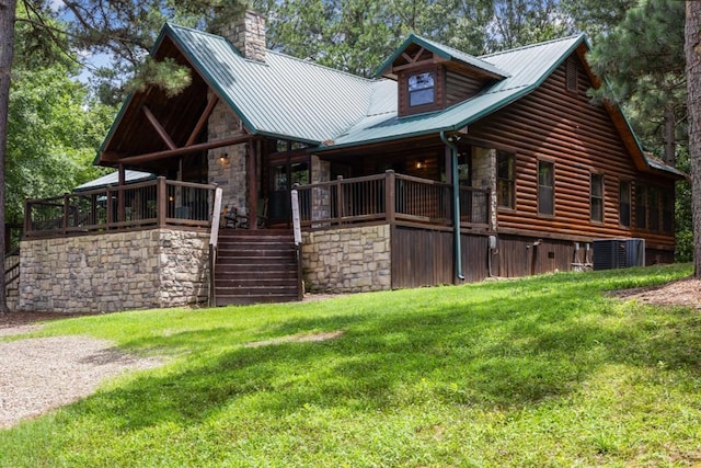 view of side of property featuring a yard, stone siding, metal roof, and stairway