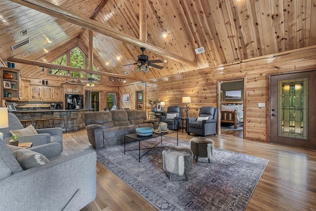 living room featuring wooden ceiling, light wood finished floors, wooden walls, and high vaulted ceiling