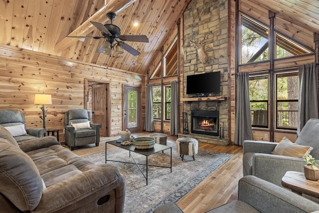 living room with high vaulted ceiling, wooden walls, a fireplace, wood ceiling, and wood-type flooring