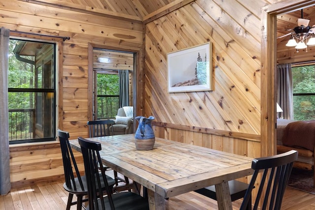 dining area with wood walls and hardwood / wood-style flooring