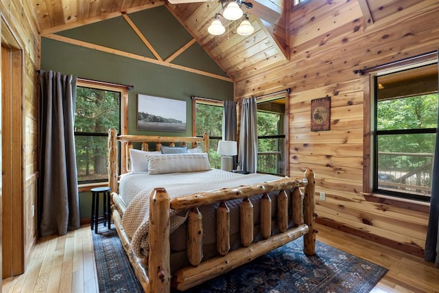 bedroom featuring multiple windows, vaulted ceiling, and hardwood / wood-style floors