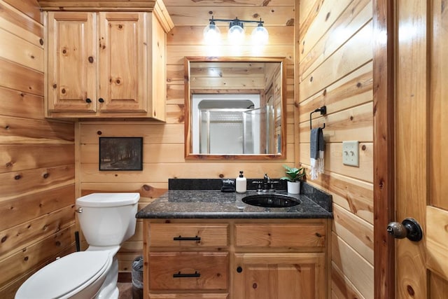 bathroom with wood walls, vanity, and toilet