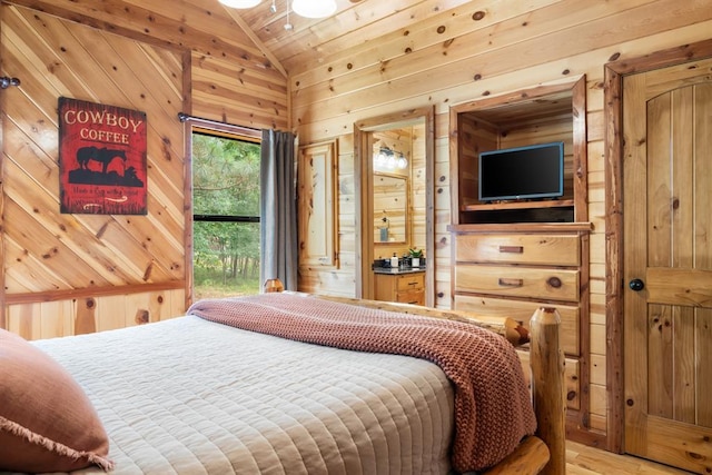 bedroom featuring lofted ceiling, wood walls, and light wood-style floors