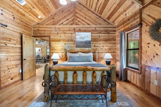 bedroom with vaulted ceiling, wood ceiling, and light wood-style floors