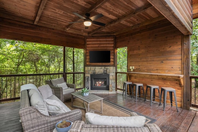 exterior space with a ceiling fan, outdoor dry bar, and an outdoor living space with a fireplace