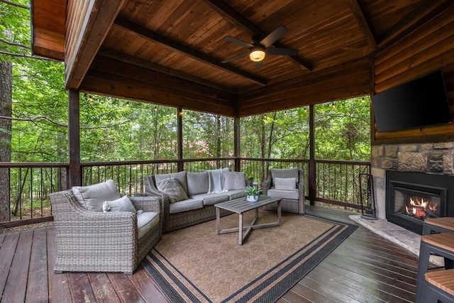 sunroom / solarium featuring plenty of natural light, beam ceiling, wooden ceiling, and an outdoor stone fireplace