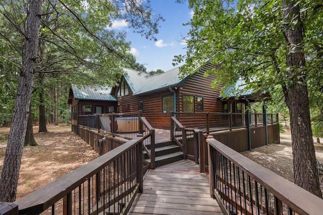 back of property featuring metal roof and a wooden deck