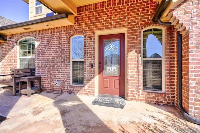 doorway to property featuring brick siding