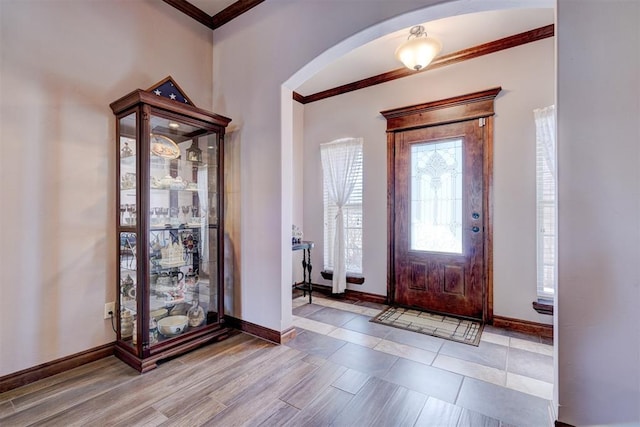 foyer entrance with baseboards and ornamental molding