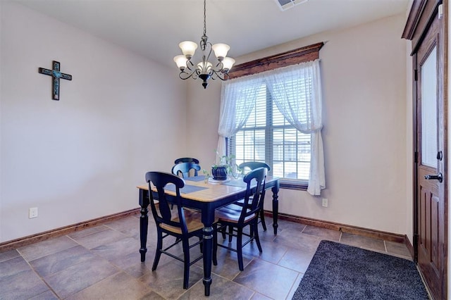 dining space featuring baseboards and a notable chandelier