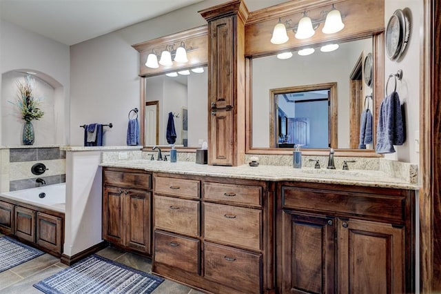 full bathroom featuring double vanity, a garden tub, and a sink