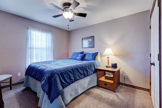 bedroom with a ceiling fan, carpet flooring, a textured wall, and baseboards