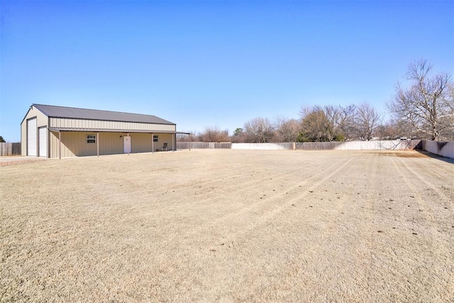 view of yard featuring an outbuilding, a detached garage, and fence