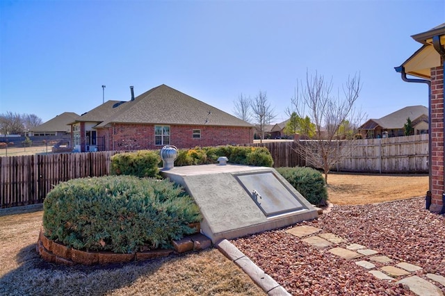 entry to storm shelter with a fenced backyard