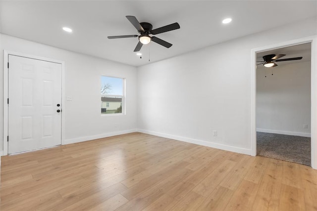 empty room with baseboards, light wood finished floors, and recessed lighting