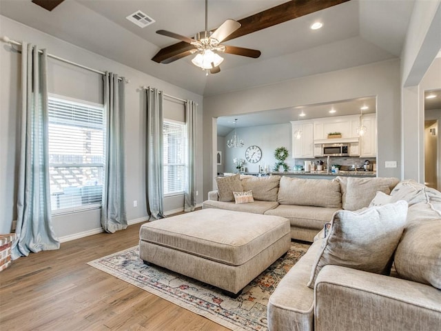 living room featuring light wood-style flooring, recessed lighting, ceiling fan with notable chandelier, visible vents, and baseboards