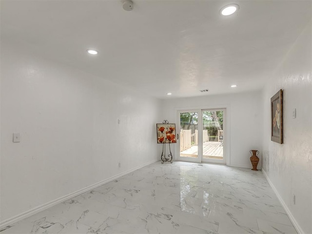 unfurnished room with marble finish floor, baseboards, and recessed lighting