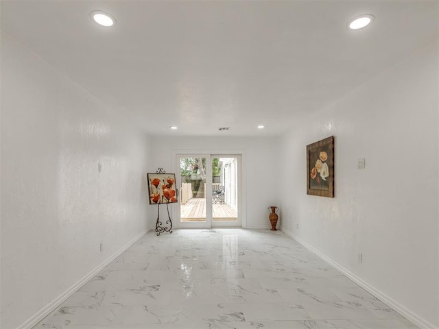 unfurnished living room featuring marble finish floor, baseboards, and recessed lighting