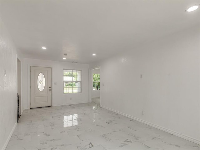 foyer entrance with marble finish floor, recessed lighting, and baseboards