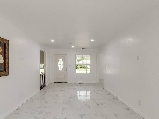 foyer entrance with marble finish floor, recessed lighting, and baseboards