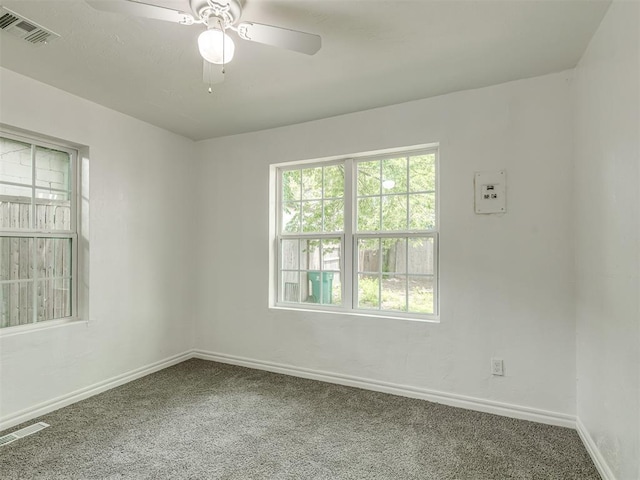 spare room featuring carpet floors, baseboards, and visible vents