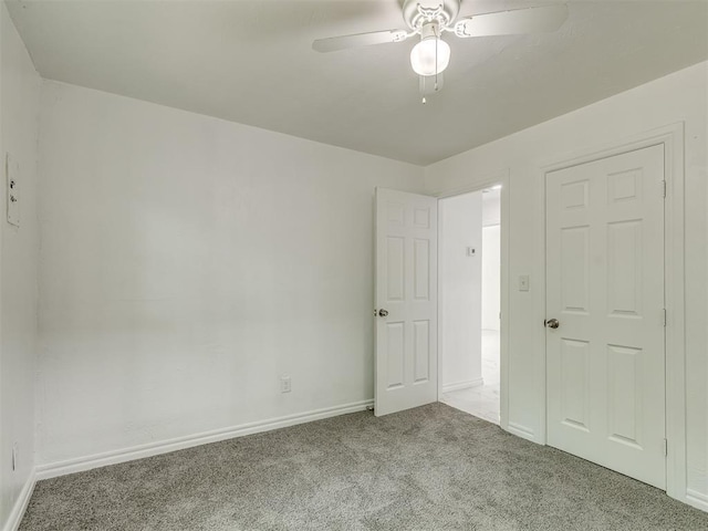 unfurnished bedroom featuring carpet, a ceiling fan, and baseboards