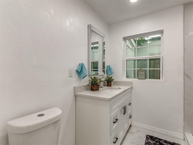 bathroom featuring a textured wall, toilet, vanity, baseboards, and marble finish floor