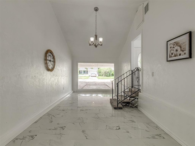 hallway featuring baseboards, stairway, marble finish floor, vaulted ceiling, and a chandelier