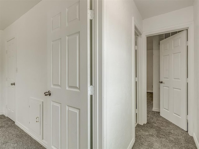 hallway with baseboards and carpet flooring