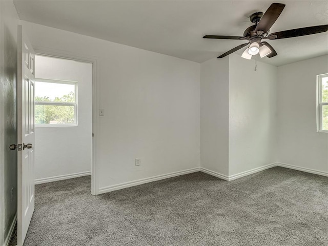 empty room featuring ceiling fan, plenty of natural light, carpet flooring, and baseboards