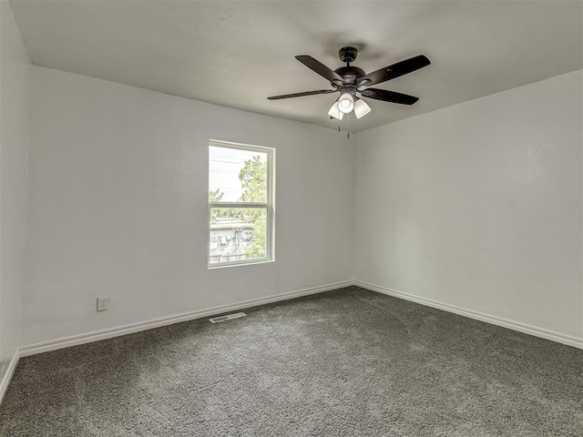 carpeted empty room with a ceiling fan, visible vents, and baseboards