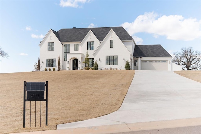 view of front facade featuring a garage, concrete driveway, and stucco siding