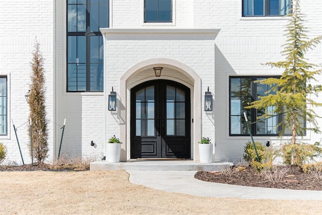 view of exterior entry featuring brick siding