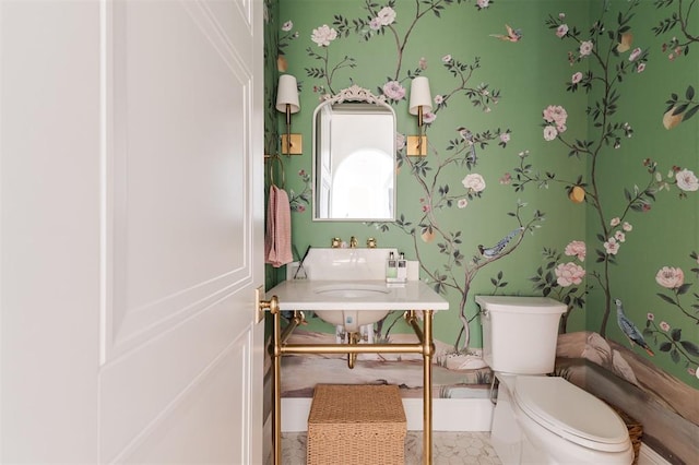 half bathroom with toilet and wallpapered walls