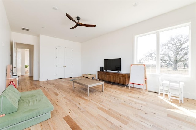 living area with visible vents, ceiling fan, and light wood-style flooring