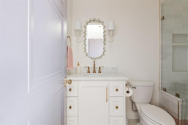 full bath featuring a tile shower, vanity, and toilet