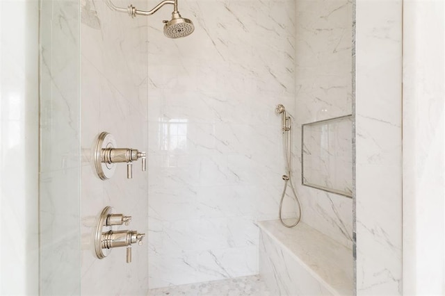 bathroom featuring a marble finish shower