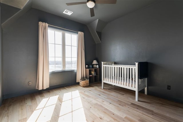 unfurnished bedroom with visible vents, vaulted ceiling, and wood finished floors